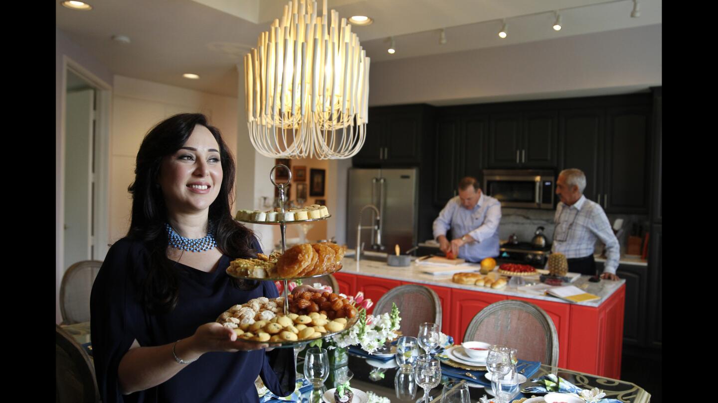 Hasty Torres is ready for entertaining in the redecorated Beverly Hills condo she shares with her husband, Jacques, center. Her father, Jahan Khoei, looks on while Jacques prepares the meal.