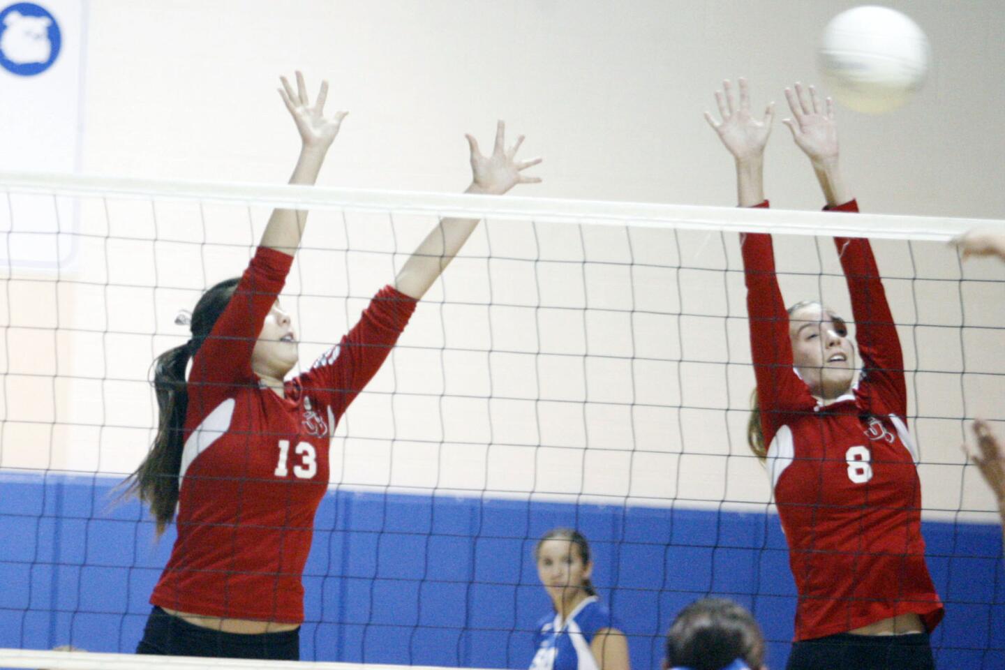 Burroughs' Caitlin Cottrell, left, and Danielle Ryan block a spike during a game against Burbank at Burbank High School on Wednesday, October 30, 2012.