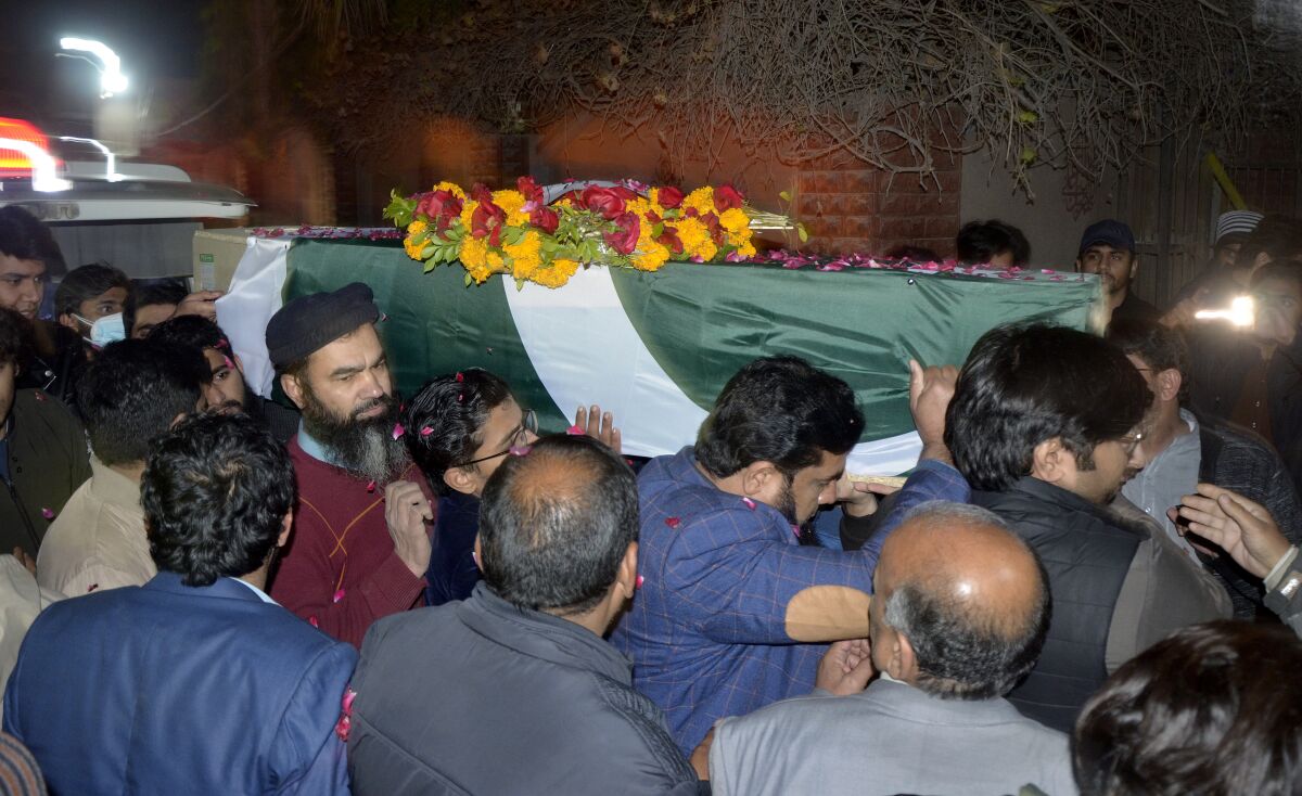 Relatives and friends carry the body of an army soldier, who was killed during gun-battle with militants in an area of country's volatile southwestern Baluchistan province, upon body's arrival at his native home, in Faisalabad, Pakistan, Thursday, Feb. 3, 2022. Twin attacks by separatists on Pakistani military posts in the country's volatile southwestern Baluchistan province triggered intense firefights that lasted hours and left seven soldiers and 13 assailants dead, the country's interior minister and the military said. (AP Photo/Abdul Majid)