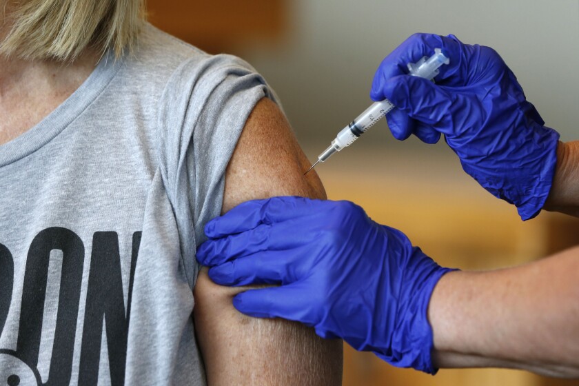 FILE - In this Monday, July 12, 2021, file photo, Karen Martin receives a COVID-19 vaccine at a vaccination clinic hosted by James River Church West Campus in conjunction with Jordan Valley Community Health Center in Springfield, Mo. COVID-19 cases have doubled over the past three weeks, driven by the fast-spreading delta variant, lagging vaccination rates in some states and Fourth of July gatherings. The five states with the biggest two-week jump in cases per capita all had lower rates, Missouri, 45.9%; Arkansas, 43%, Nevada, 50.9%, Louisiana, 39.2% and Utah, 49.5%. (Nathan Papes/The Springfield News-Leader via AP, File)