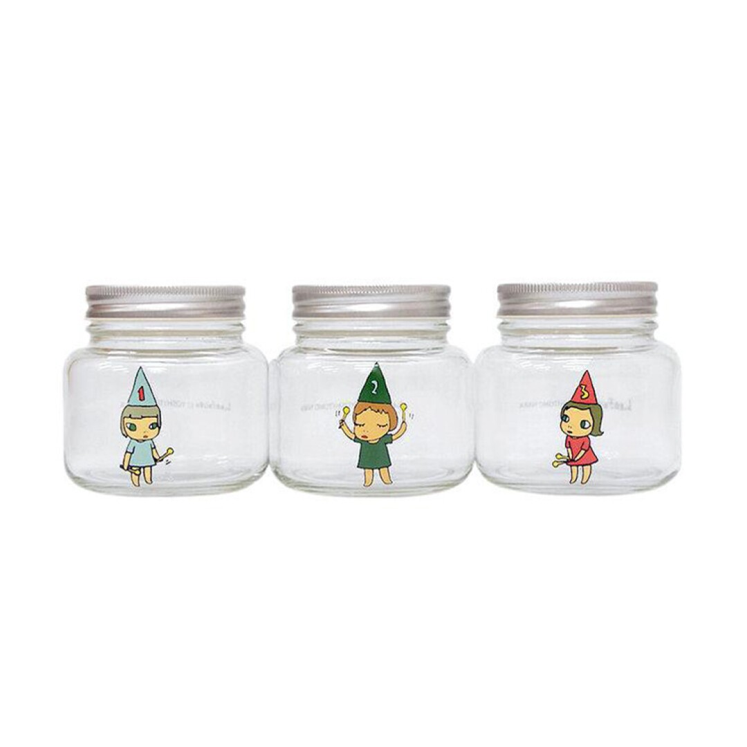 Three clear glass jars, each painted with the figure of a girl wearing a numbered, pointed hat.