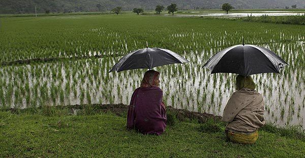 Two women wait for their husbands to return from their work in the fields.