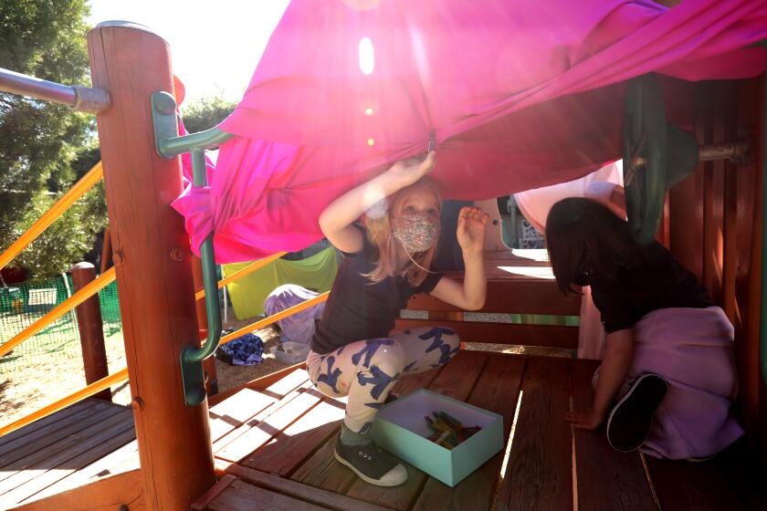 SANTA MONICA, CA - FEBRUARY 23, 2021 - - Kindergarten students Ray, left, and Emmy Lou, both 6, build a fort while attending the Kigala Preschool in Santa Monica on February 23, 2021. The school has been admitting students from kindergarten through 1st grade. With most K-12 schools still closed across California, preschools and daycares have adopted older children into their programs. Often, up to a third of children in these facilities are learning remotely from shuttered public schools. But preschool and daycare providers make far less than their K-12 counterparts, and are far more likely to be women of color. The added complexity and expense of caring for older children has strained an already struggling system. (Genaro Molina / Los Angeles Times) ATTENTION EDITOR: DIRECTOR OF SCHOOL ONLY WANTED FIRST NAME OF STUDENTS USED.