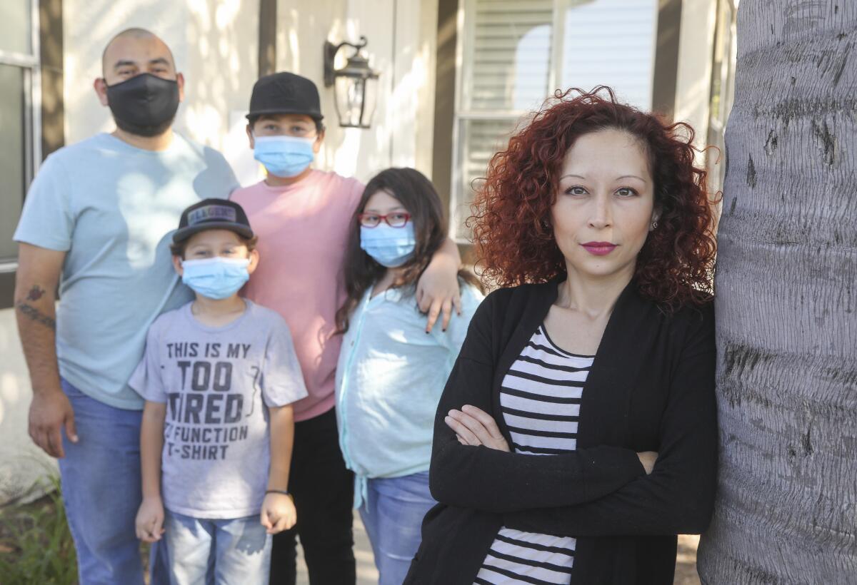 Davida Dueñas, right, and her husband, Victor Zamudio, and their children, from left, Sayid Zamudio, 7; David Zamudio, 13, and Emily Zamudio, 10, stand outside their Chula Vista home on May 1.