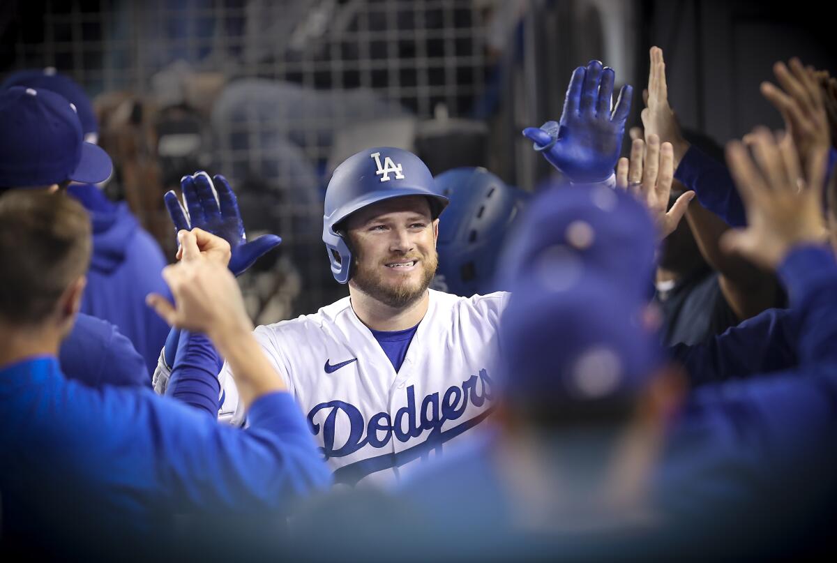 Max Muncy is congratulated by his Dodgers teammates after hitting a home run.