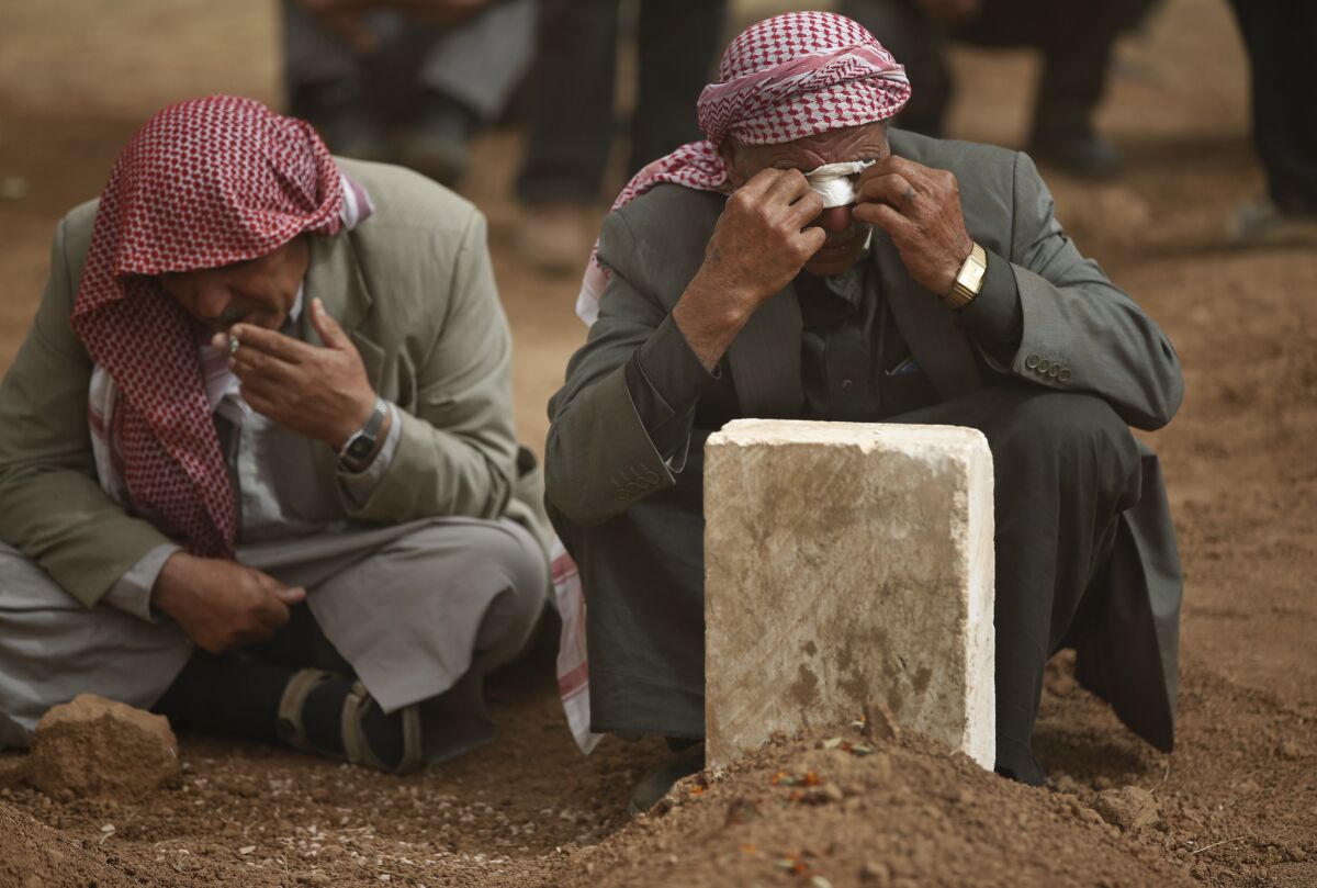 Men in Suruc, a town on the Turkish side of the border with Syria, mourn at the grave of a relative who was killed battling Islamic State militants in the Kurdish city of Kobani in northern Syria.
