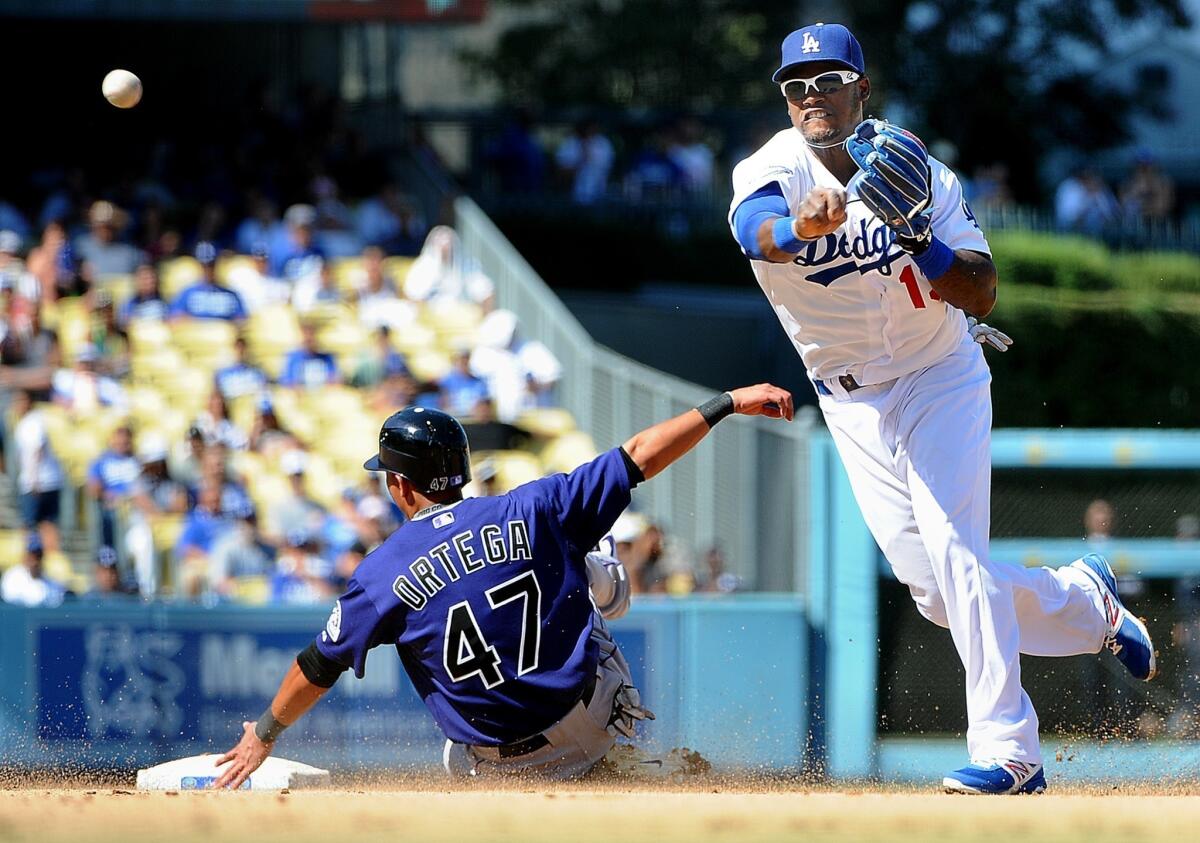 The Rockies' Rafael Ortega is out at second base at the hands of Hanley Ramirez, during a double play at Dodger Stadium.