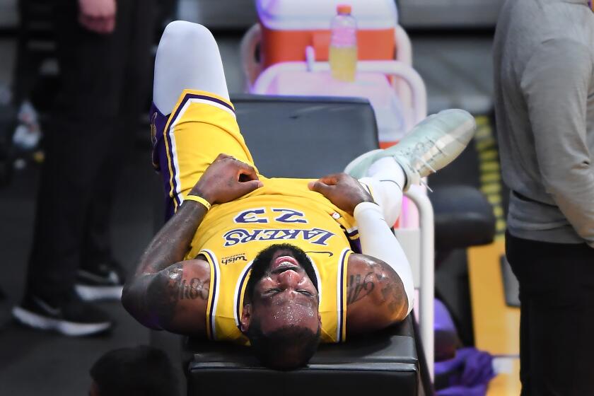 LOS ANGELES, CALIFORNIA FEBRUARY 8, 2021-Lakers LeBron James lays on a table during a timeout in overtime against the Thunder at the Staples Center Monday. (Wally Skalij/Los Angeles Times)