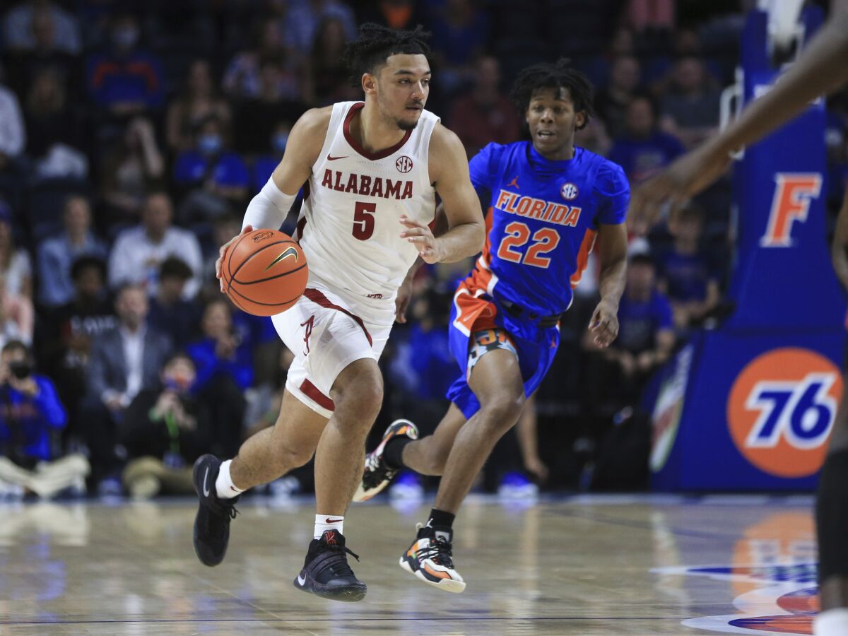 Alabama guard Jaden Shackelford (5) brings the ball up past Florida guard Tyree Appleby (22) during the first half of an NCAA college basketball game Wednesday, Jan. 5, 2022, in Gainesville, Fla. (AP Photo/Matt Stamey)
