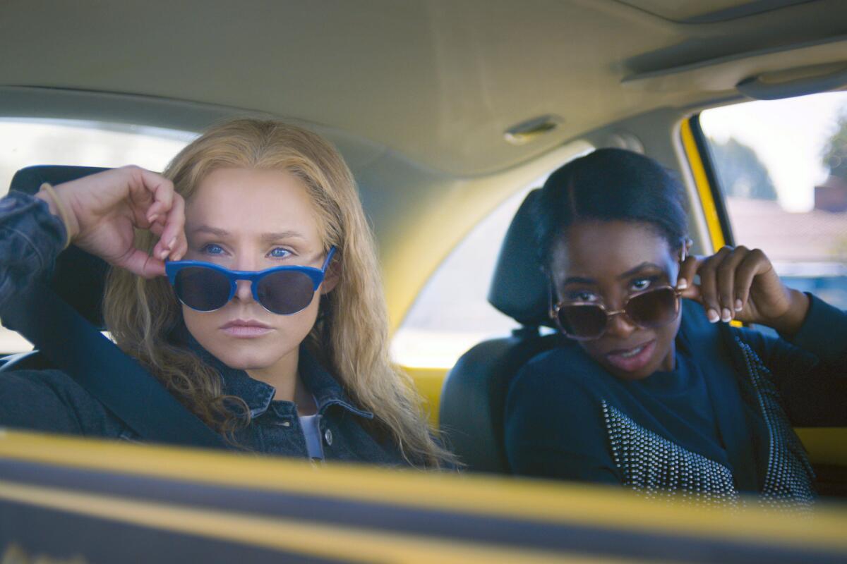This image released by STX Films shows Kristen Bell, left, and Kirby Howell-Baptiste in a scene from "Queenpins." (STX Films via AP)