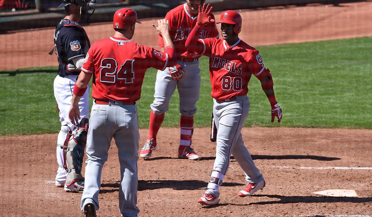 Angels' Gregorio Petit, right, celebrates with teammate CJ Cron after hitting his second home run of the game during a spring training game against the Cleveland Indians on Wednesday in Goodyear, Ariz.