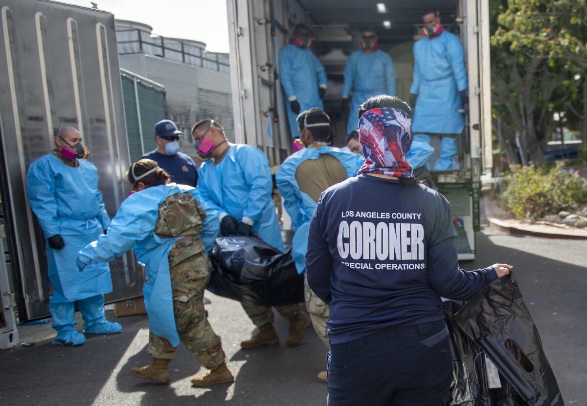 National guardsmen carry a bodybag as a staff member of the L.A. County coroner's office looks on.  