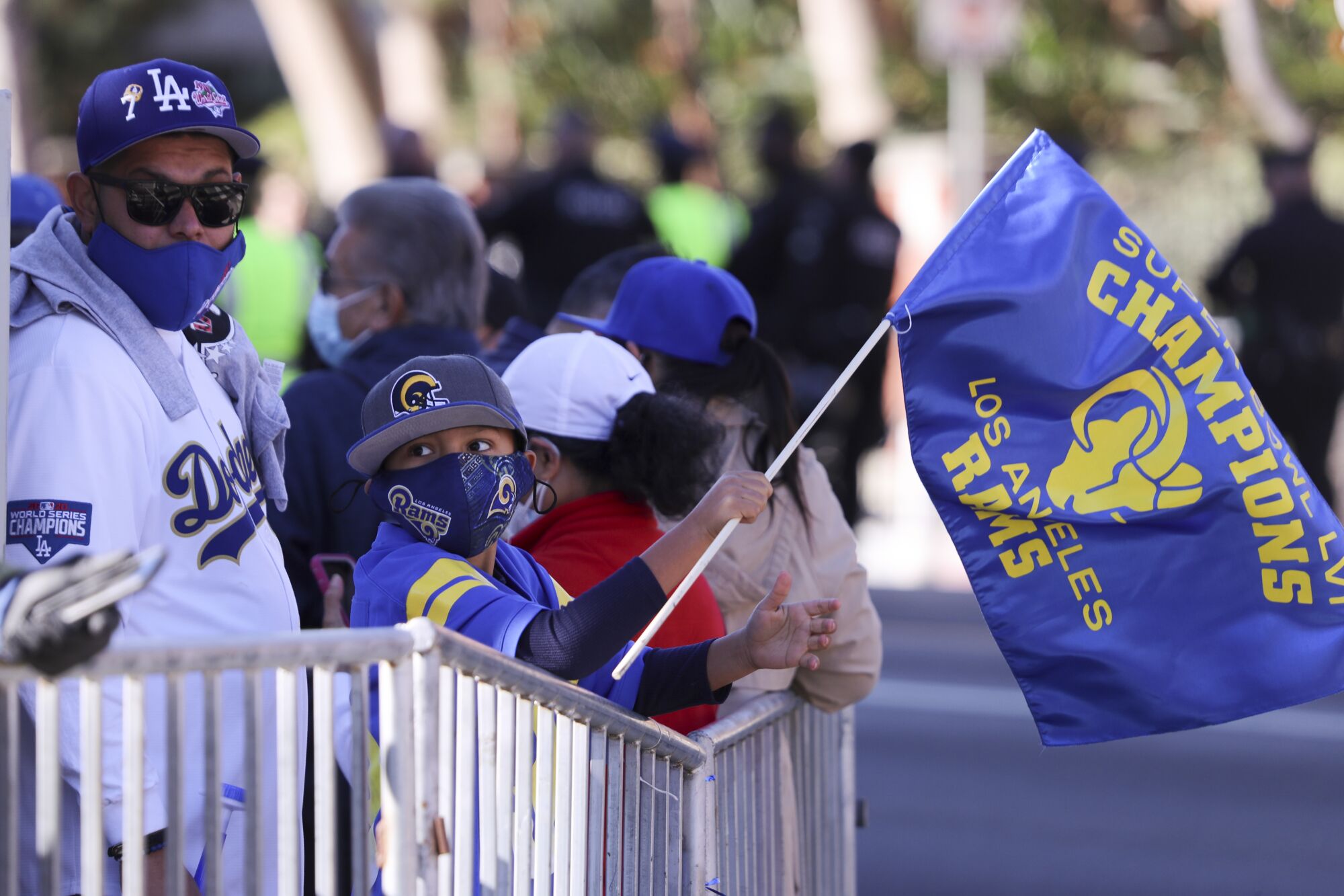 A masked man and boy wait for the Rams parade to start.