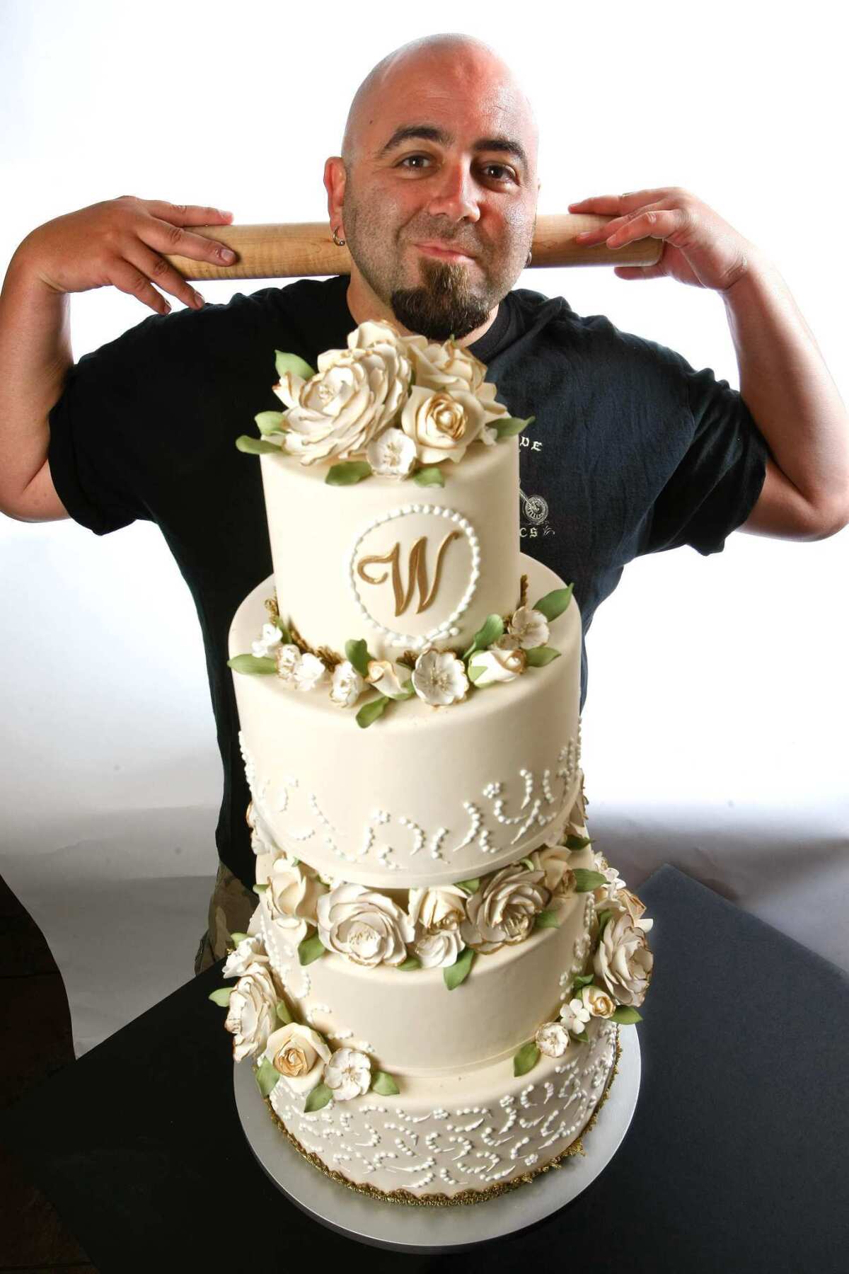 Duff Goldman, the cake baker behind the "Ace of Cakes" TV show, is photographed next to one of his designer cakes, a floral wedding cake at Charm City Cakes West, his new bakery in Los Angeles.