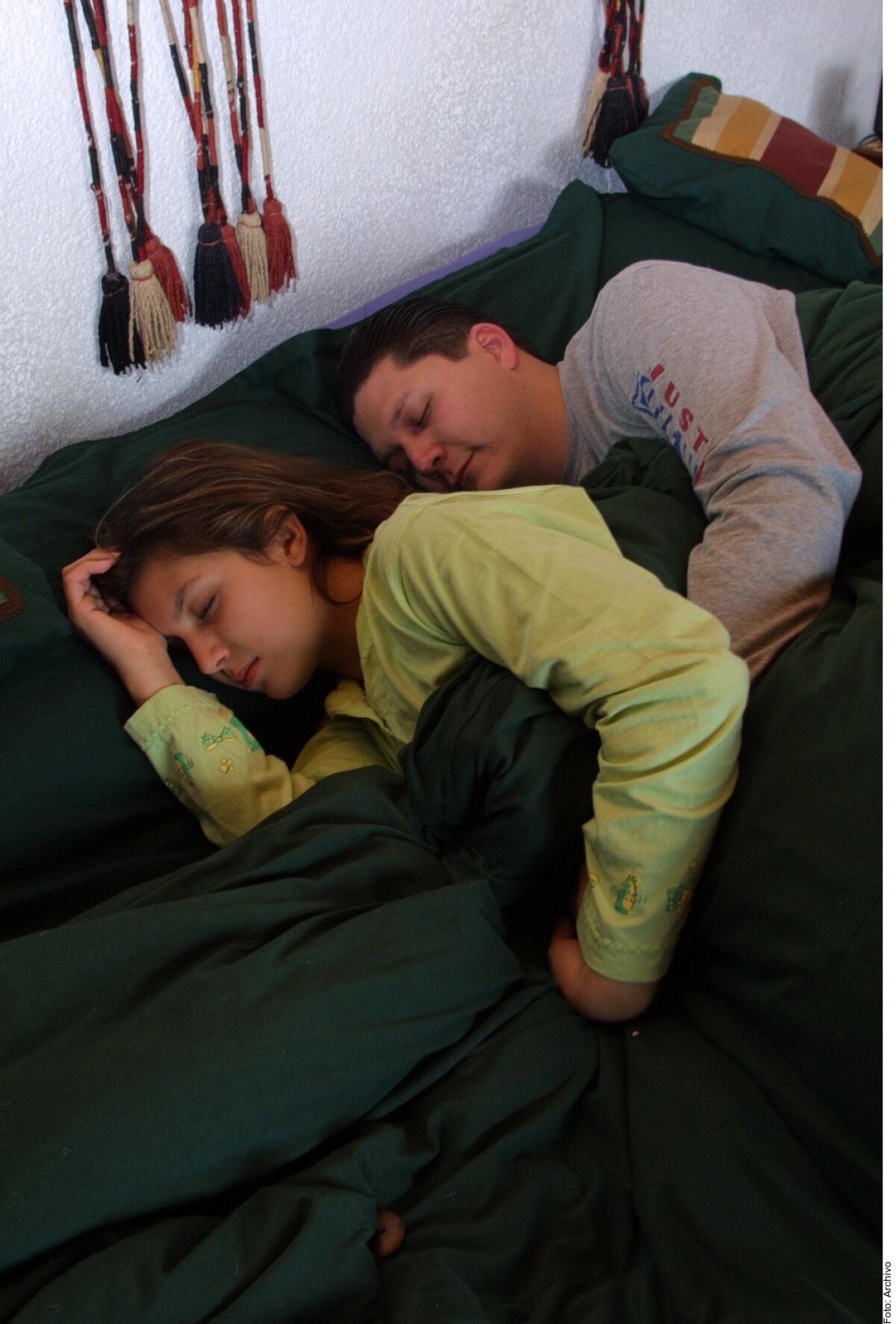 Una pareja duerme sobre su cama