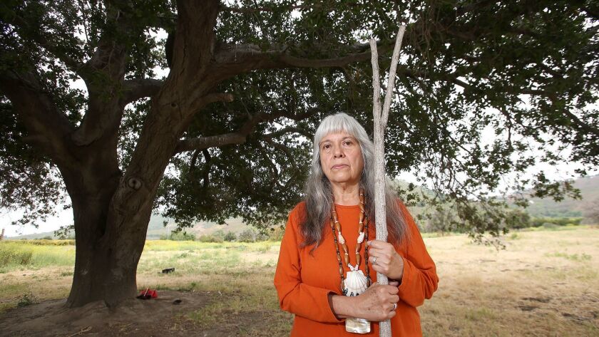 Juaneño spiritual leader Adelia Sandoval stands next to the Mother Tree, an oak on the grounds of the one of the first Native American settlements in what became Orange County.