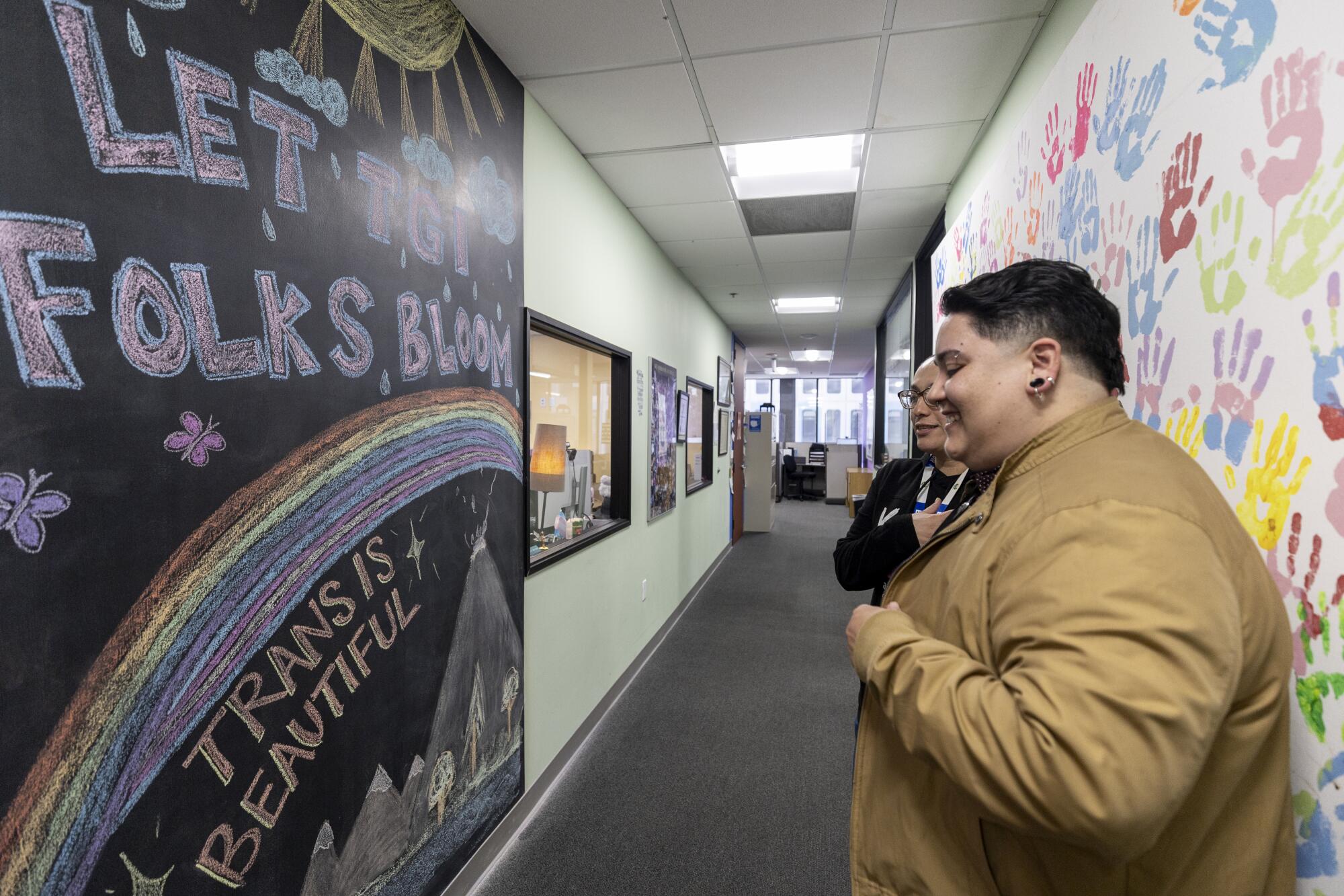 People look at a mural in a hallway of the TransLatin@ Coalition's offices in Los Angeles on April 5.