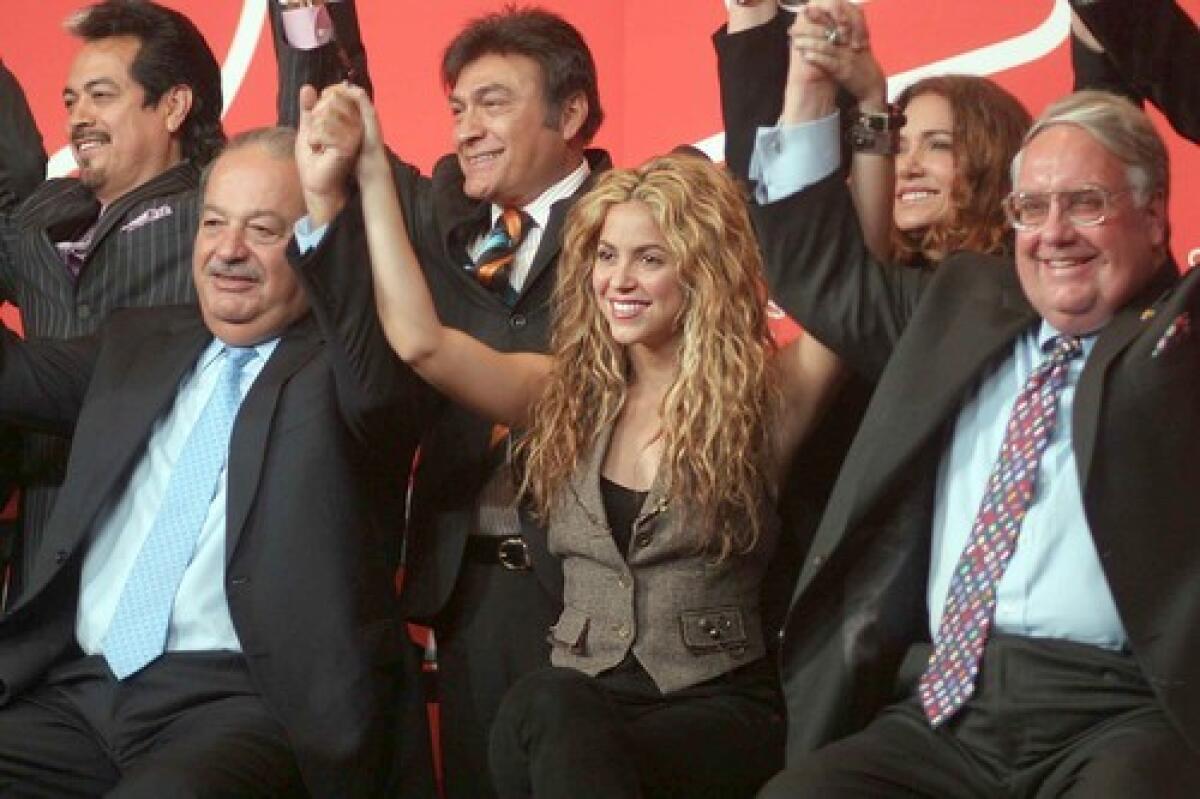 SOLIDARITY: Carlos Slim Helú (front, from left), Shakira and Howard Graham Buffett raise their interlocked hands to support early childhood development funding in Latin America.
