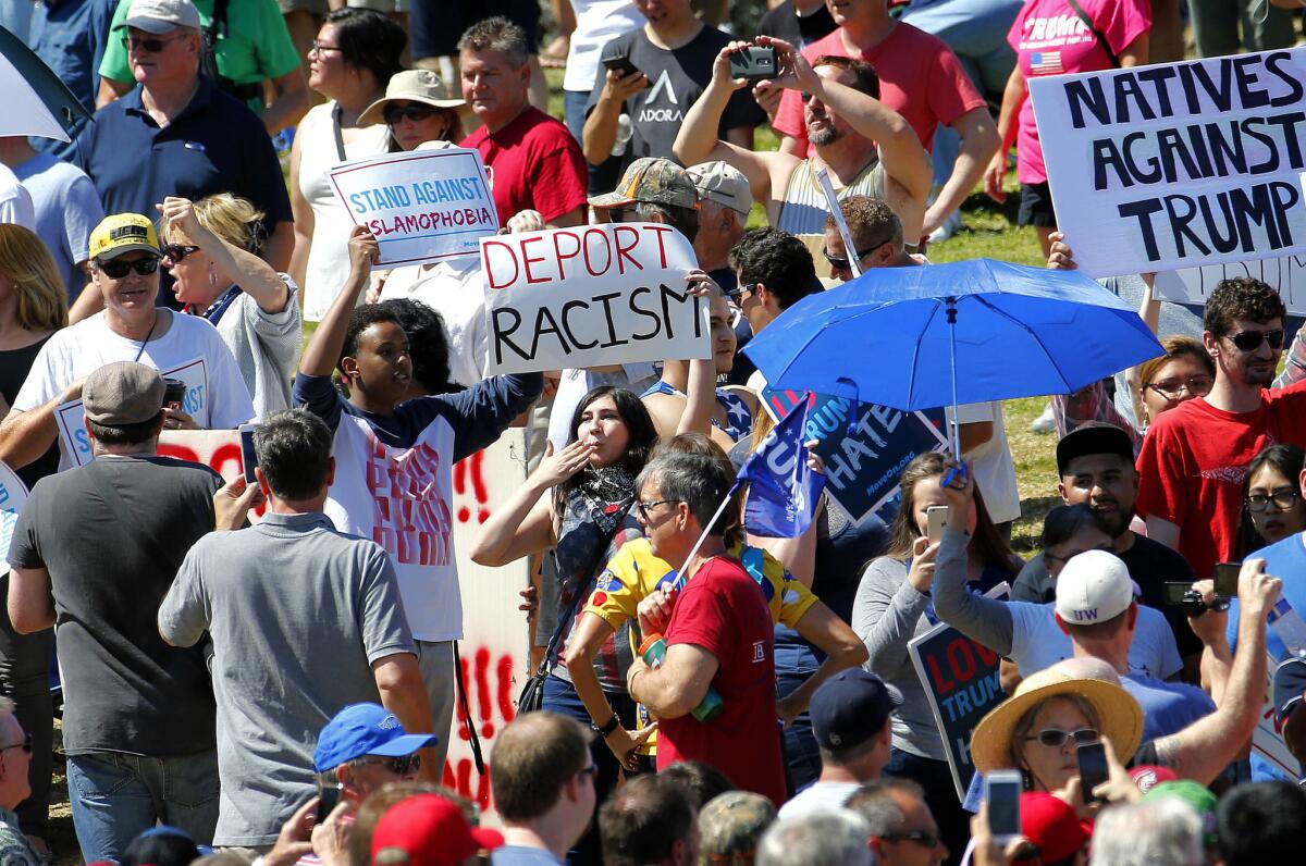 Protesters stand among Donald Trump supporters during a presidential campaign rally on March 19, 2016, in Fountain Hills, Ariz.