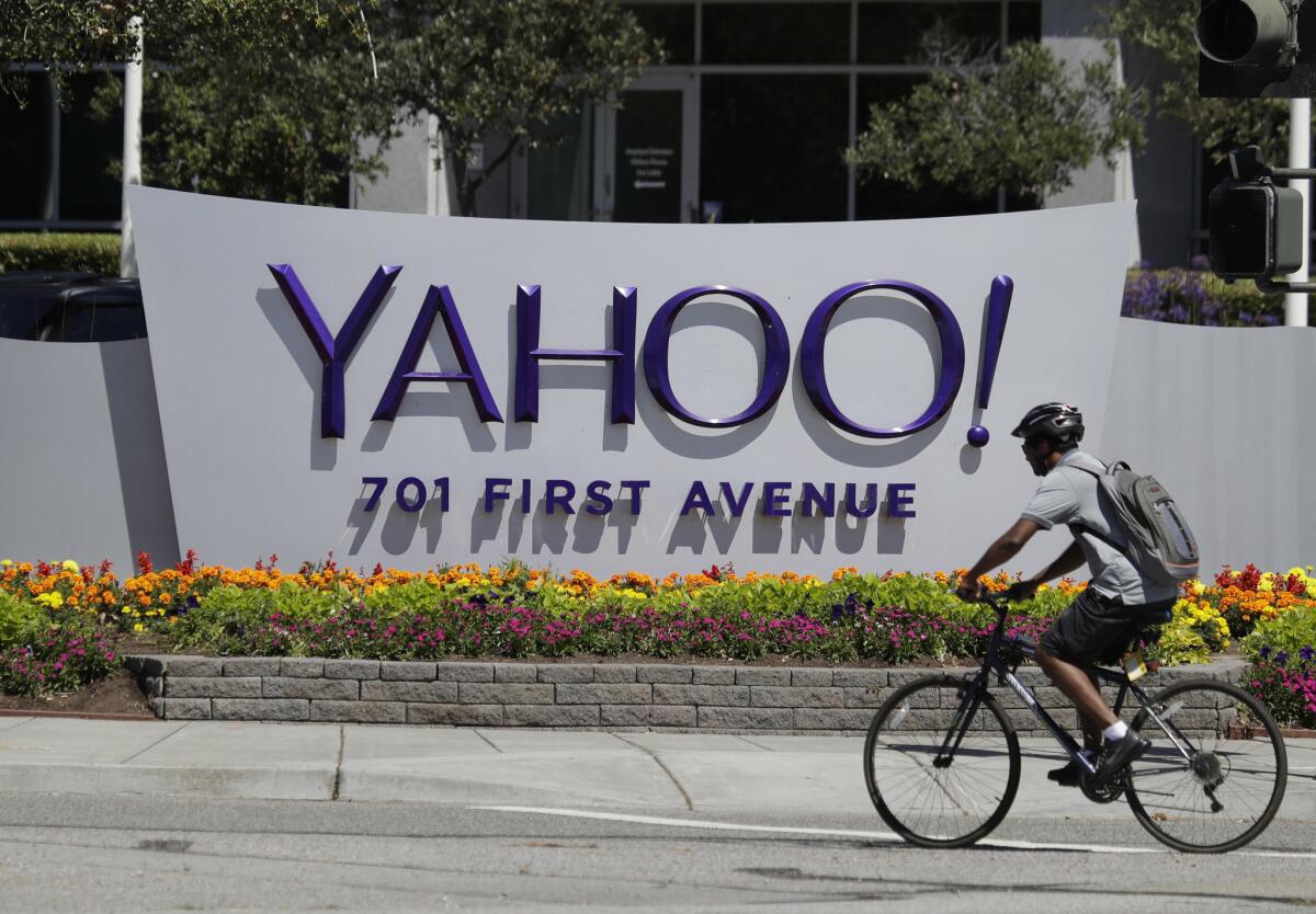 In this July 19, 2016, file photo, a cyclist rides past a Yahoo sign at the company's headquarters in Sunnyvale, Calif.