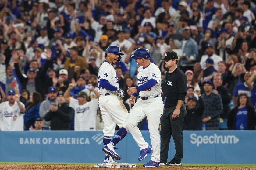 Los Angeles, CA, Thursday, September 26, 2024 - Los Angeles Dodgers shortstop Mookie Betts (50) celebrates with Los Angeles Dodgers first base coach Clayton McCullough (86) after hitting a seventh inning rbi single at Dodger Stadium. (Robert Gauthier/Los Angeles Times)