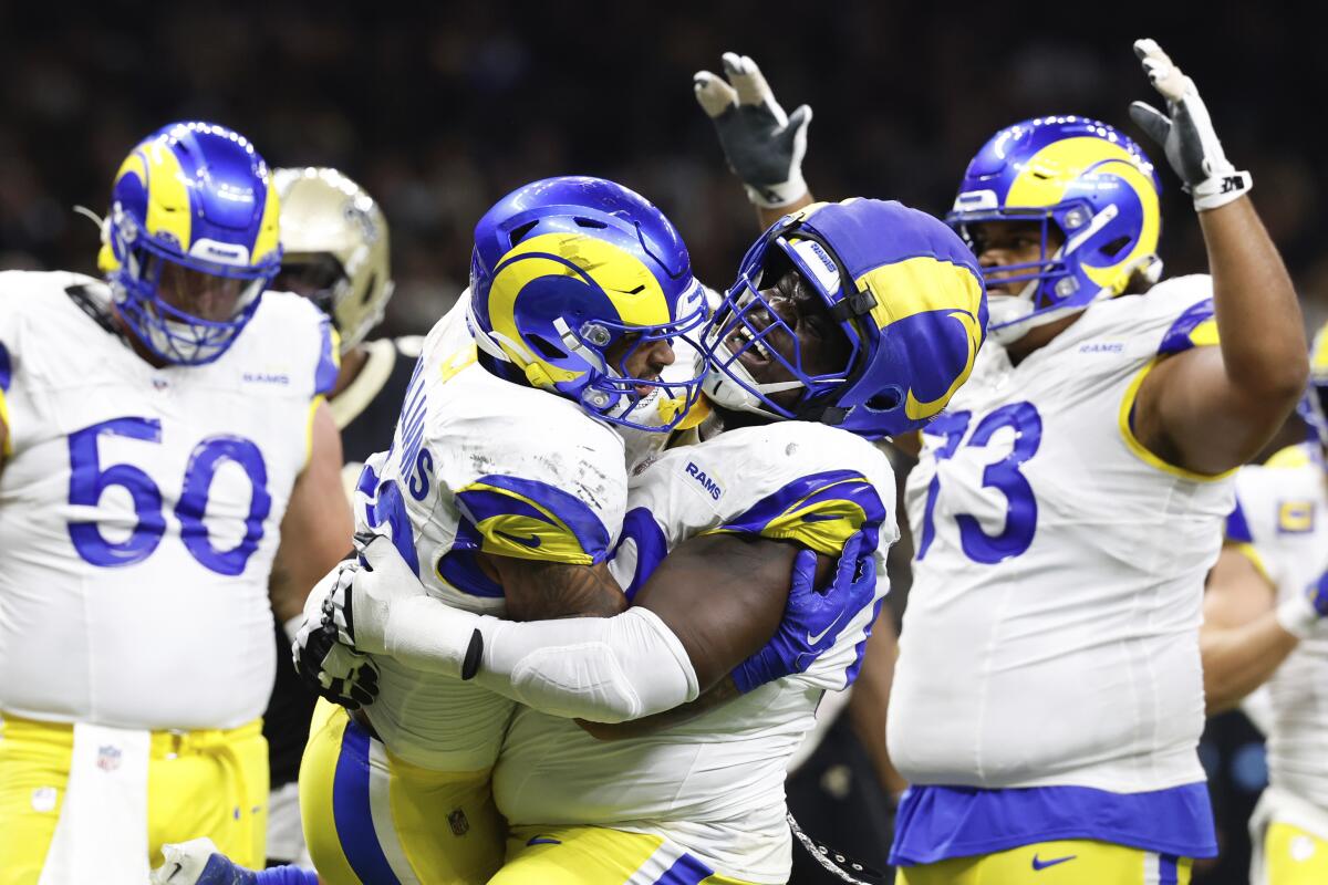 Kevin Dotson (center, right) hugs Kyren Williams after the Rams running back scored against the Saints.
