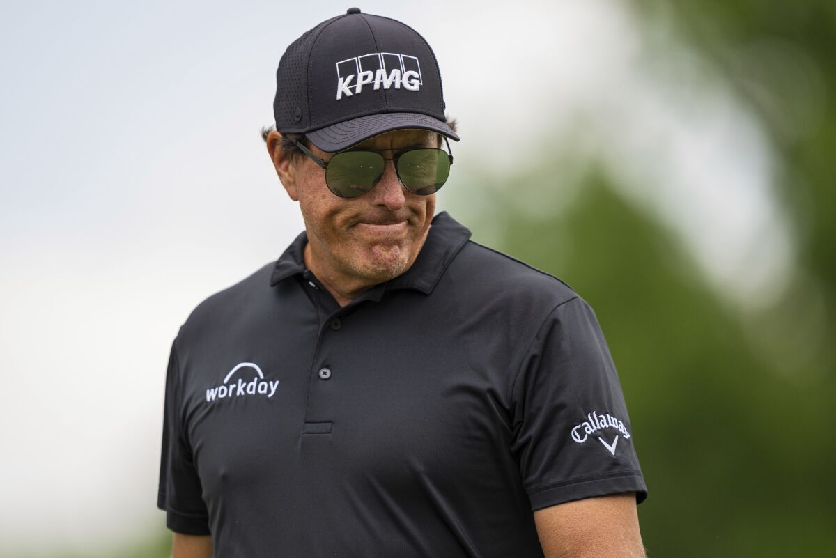 Phil Mickelson looks down after finishing on the first hole during the third round of the Wells Fargo Championship golf tournament at Quail Hollow on Saturday, May 8, 2021, in Charlotte, N.C. (AP Photo/Jacob Kupferman)