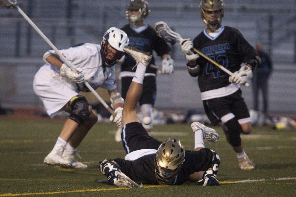 Corona del Mar's Kyle Young, center, trips while trying to gain possession of the ball during the Battle of the Bay.
