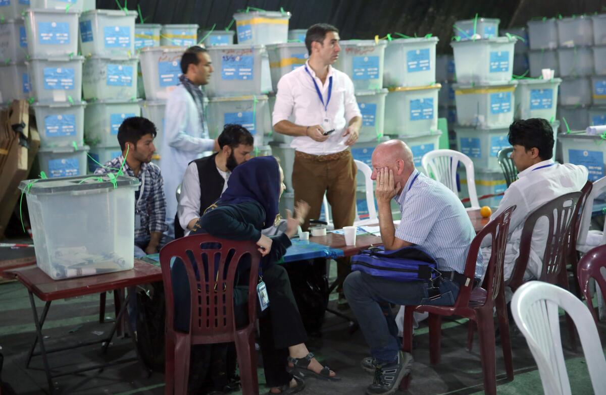 Afghan election commission workers sort ballots for an audit of the presidential runoff votes in front of international observers at an office in Kabul, Afghanistan.