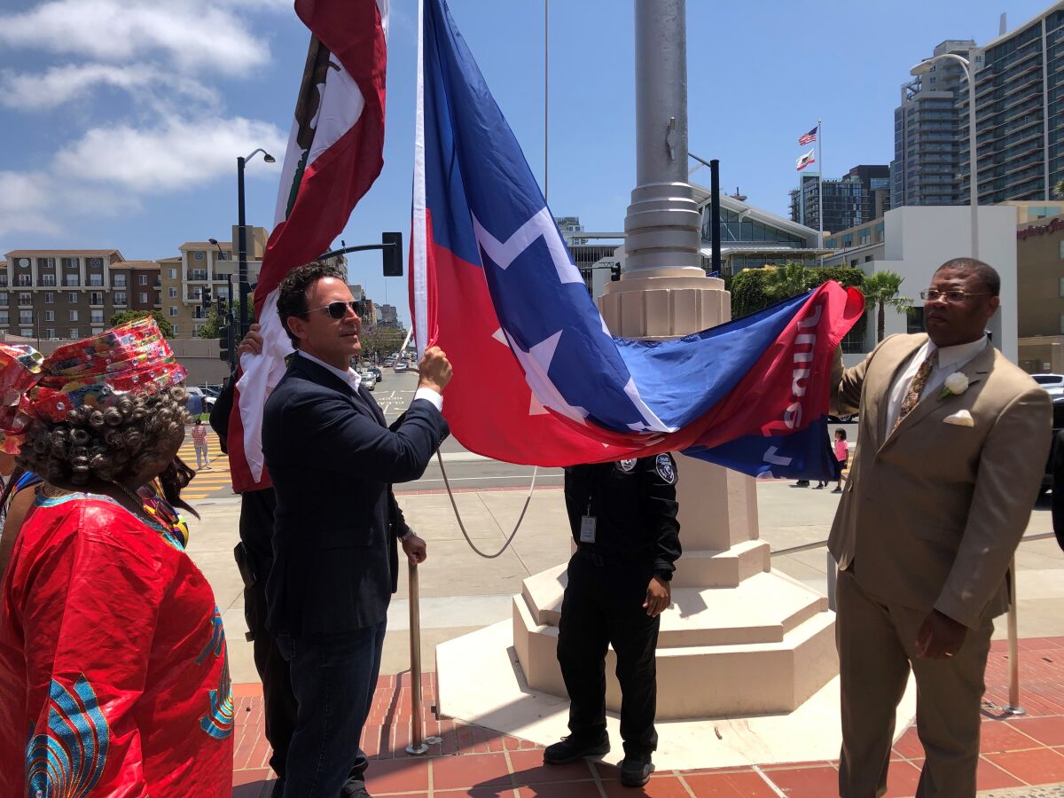 County Board Chair Nathan Fletcher and Roosevelt Williams III, CEO of Young, Black, & N' Business, raise the Juneteenth flag 