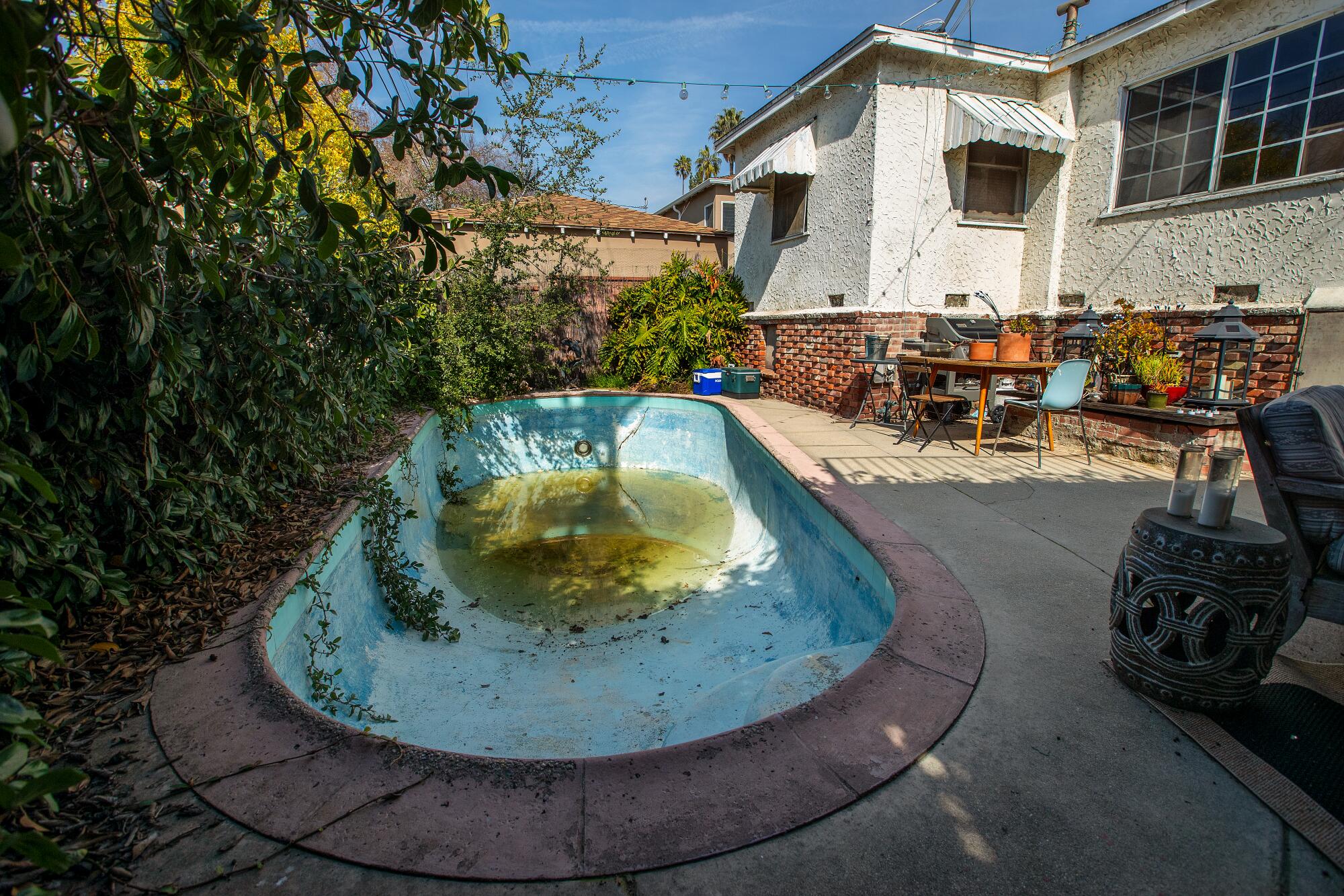 A patio outside a house with an emptied pool