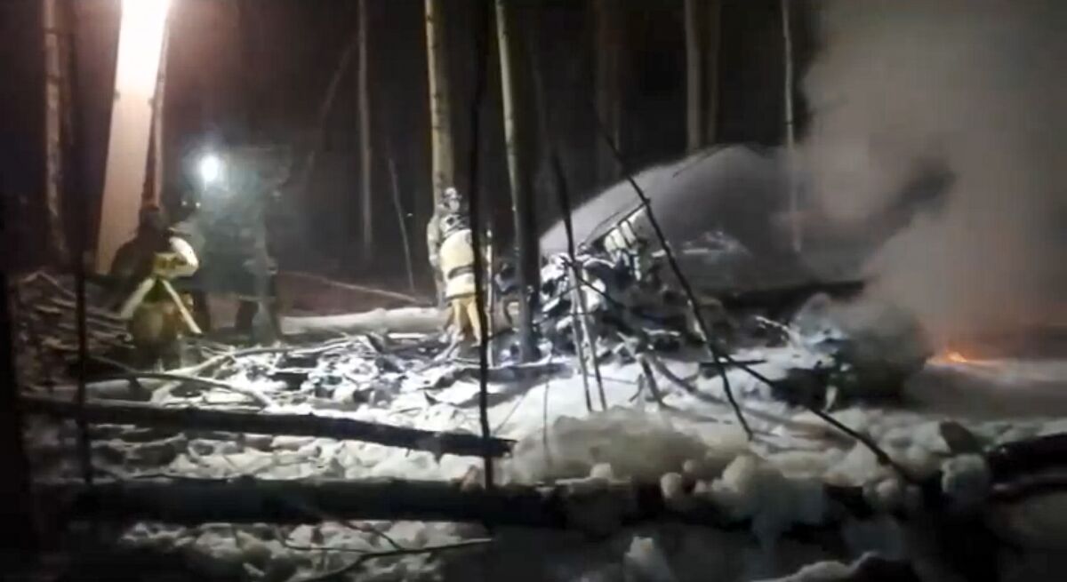 In this image from video provided by the Russian Emergency Ministry Press Service, Russian rescuers work at the side of an An-12 cargo plane crash near Irkutsk, Russia, Wednesday, Nov. 3, 2021. A Belarusian cargo plane has crashed while trying to land in eastern Russia, killing at least four people, officials said. Russian emergency workers said rescuers found four bodies after the Soviet-built An-12 operated by Belarusian carrier Grodno went down Wednesday in Irkutsk, eastern Siberia. (Russian Emergency Ministry Press Service via AP)