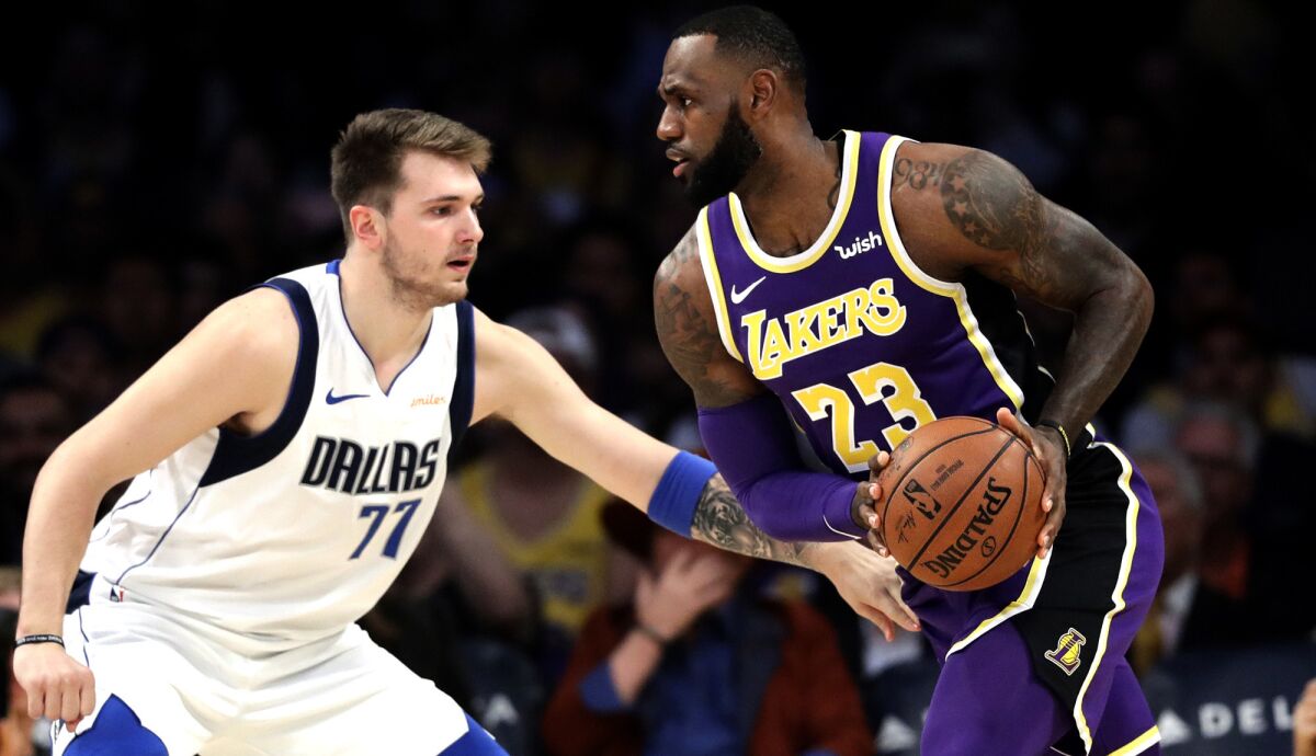 Dallas Mavericks guard Luka Doncic defends Lakers forward LeBron James.