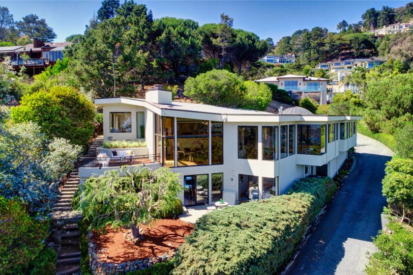 The split-level home takes in views of the Bay and Golden Gate Bridge through walls of windows.