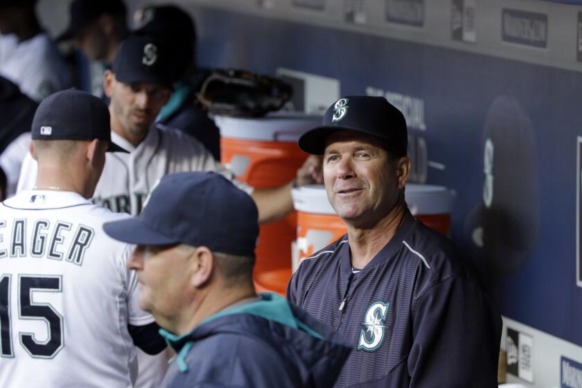 Edgar Martinez, Seattle's new hitting coach, smiles as he looks out of the dugout before the Mariners' game against Houston on Saturday.