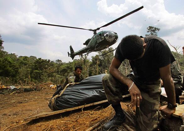 Ducking helicopter turbulence, Ecuadorean soldiers kneel by the bodies of Colombian rebels slain by Colombian forces, an operation that triggered tensions between the two countries. Colombian President Alvaro Uribe apparently decided it was worth risking the ire of his southern neighbor to enter Ecuador to kill Raul Reyes, the No. 2 man in the FARC, Colombia's largest rebel group. The incursion prompted denunciations from neighboring countries, especially Venezuela, which threatened war.
