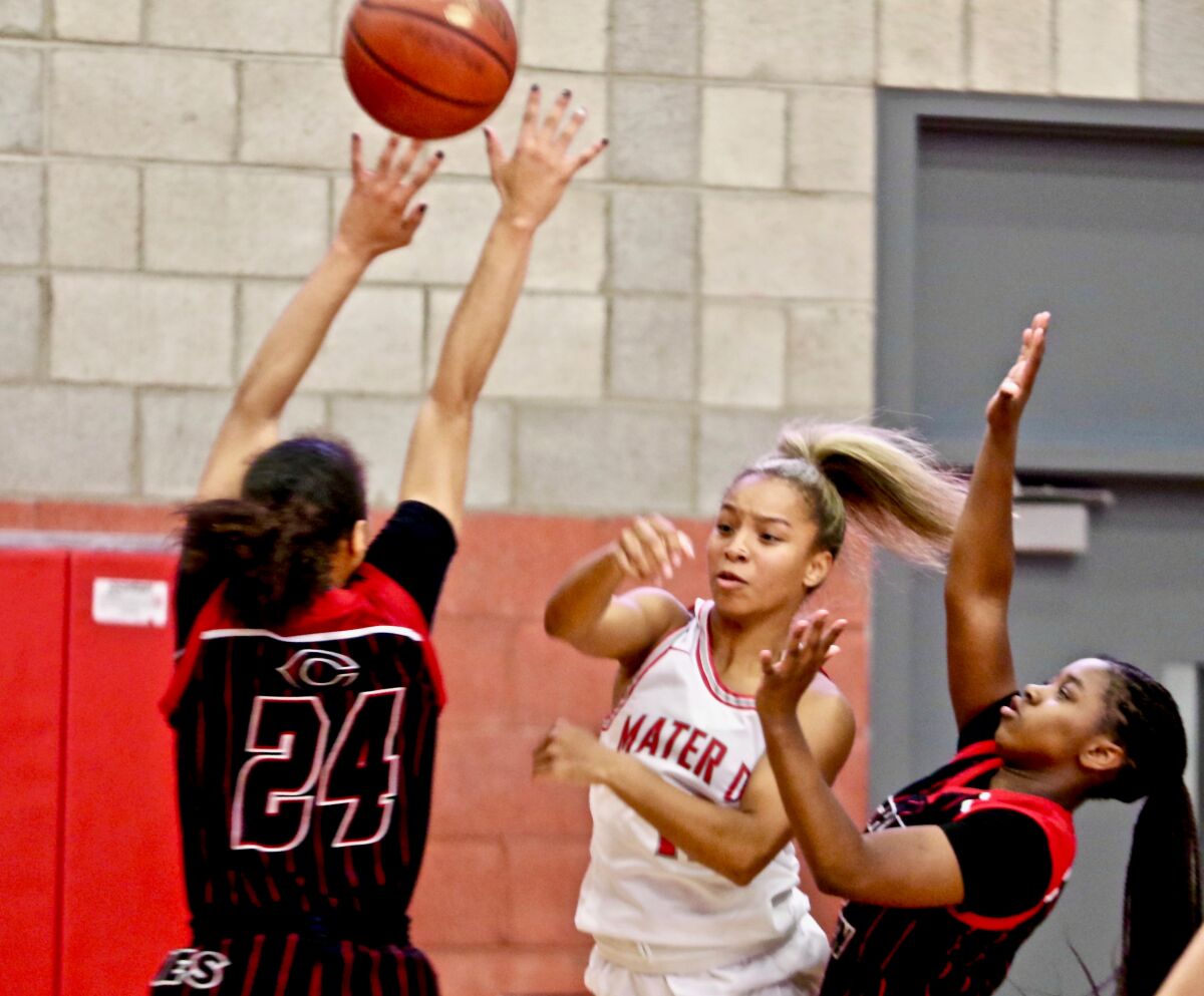Mater Dei point guard Caia Elisaldez (center) makes a pass in the lane.