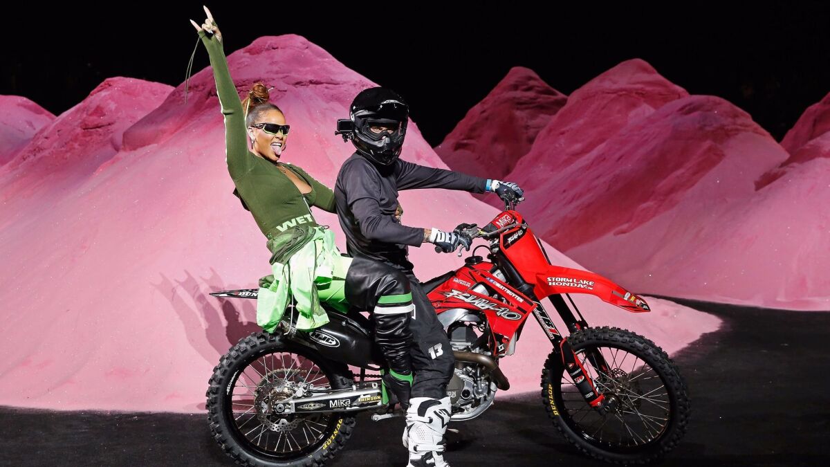 Rihanna takes her runway finale bow on the back of a motocross bike after the show.