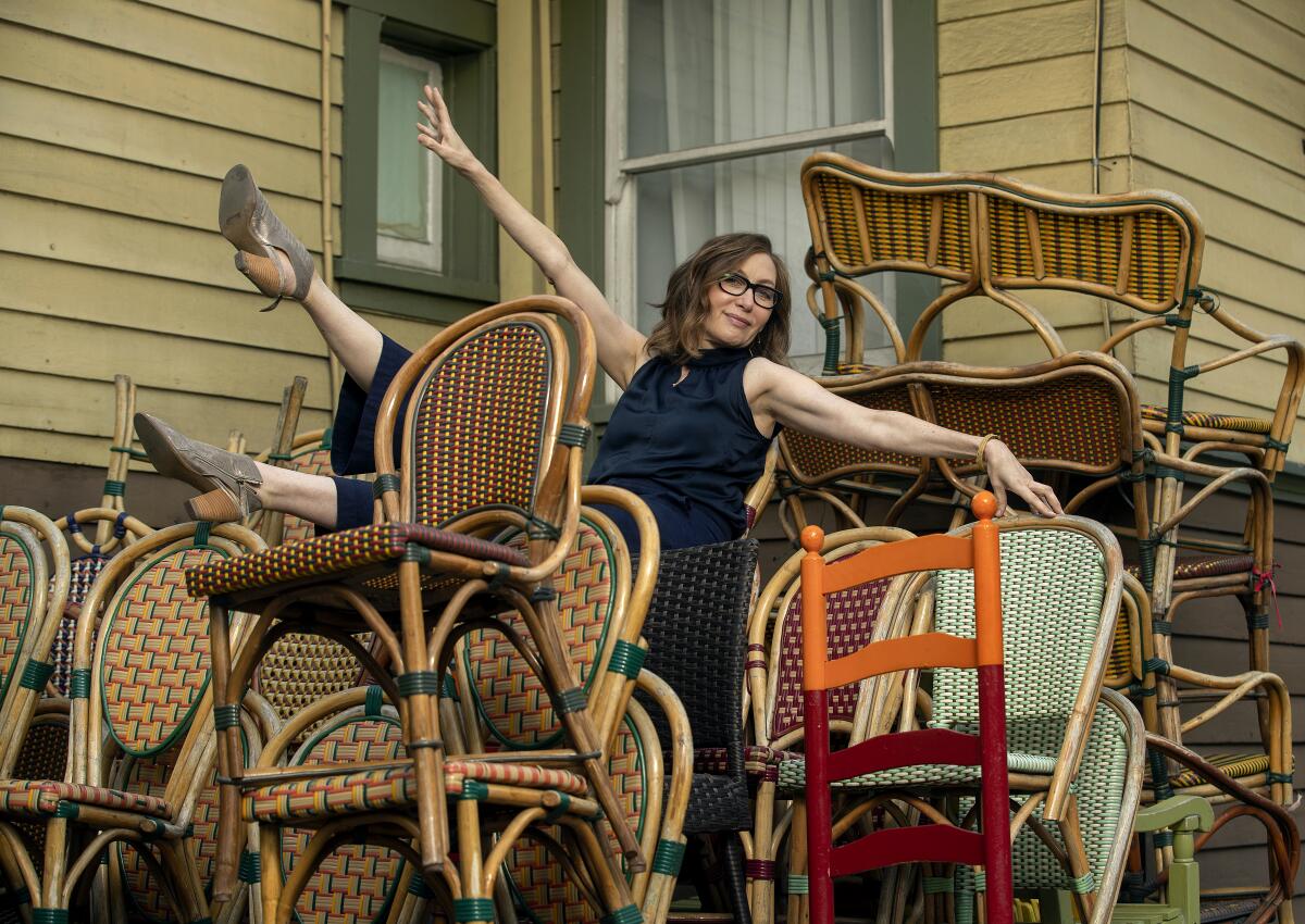 Annabelle Gurwitch, author of the new essay collection "You're Leaving When?," leans back atop a pile of chairs.