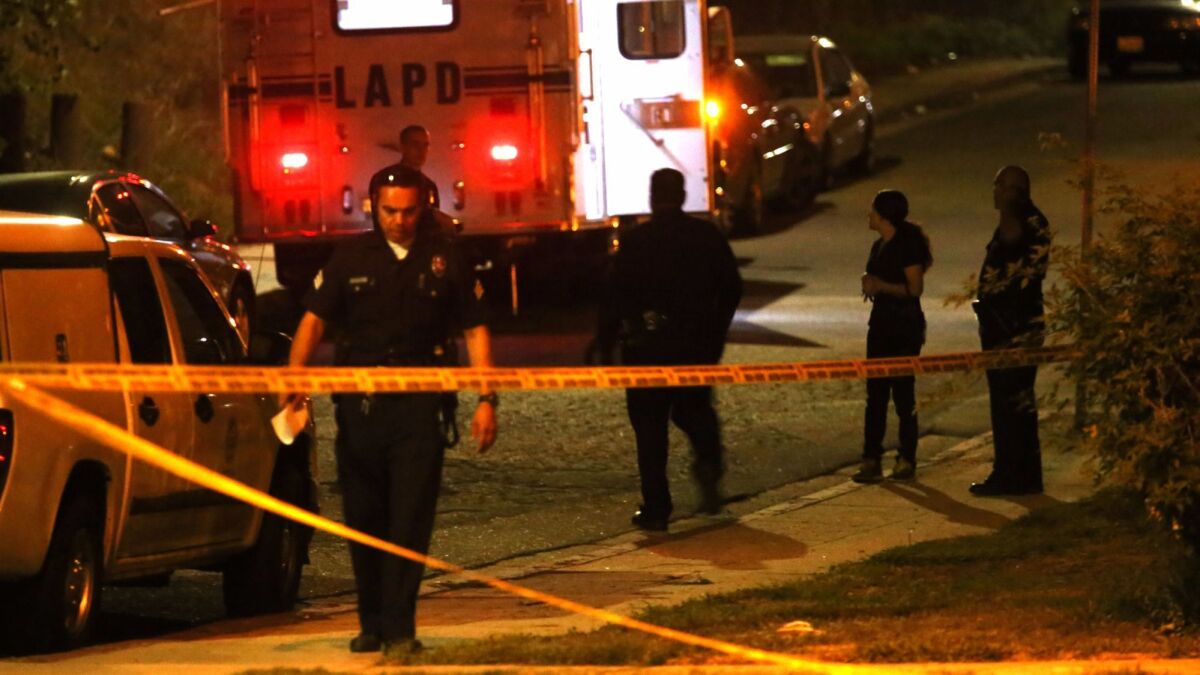 Police officers oversee a crime scene near Ernest E. Debs Regional Park in Los Angeles in 2015.