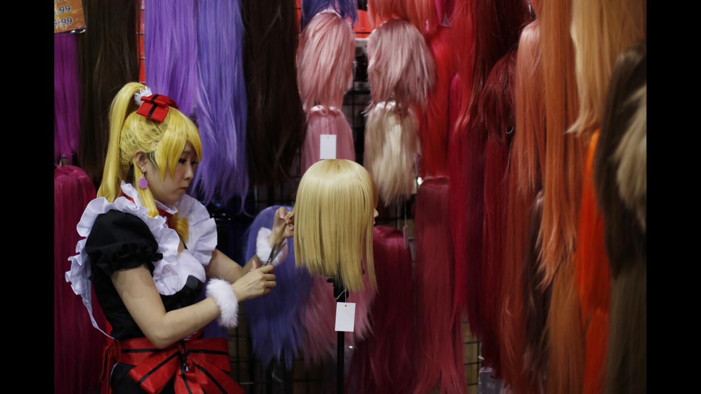 A staffer at the "Assist Cosplay" booth trims a wig at the Anime Expo 2015 at the Convention Center in Los Angeles.