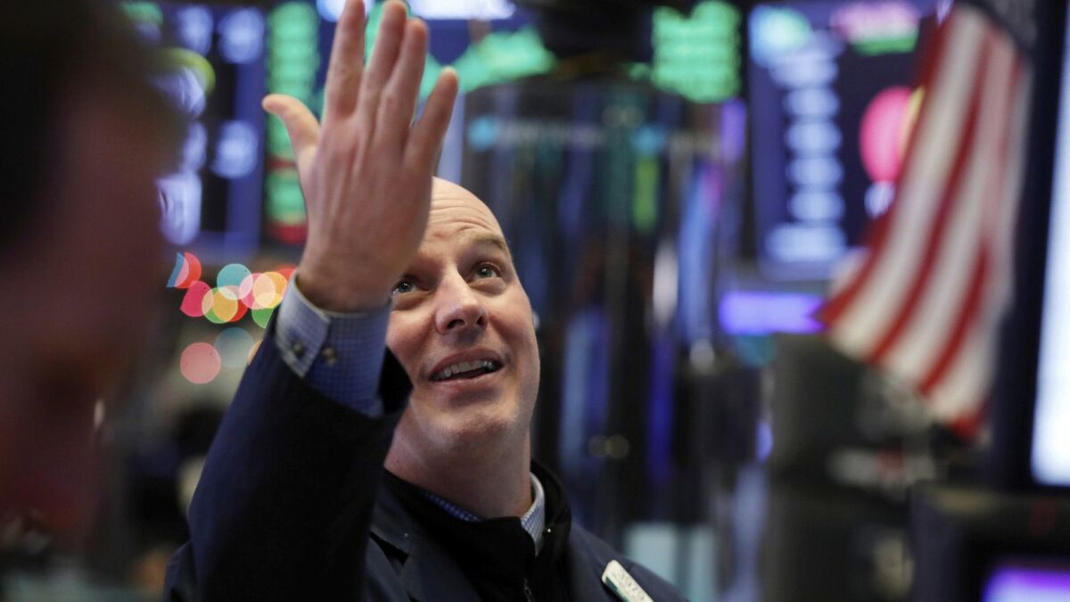 Specialist John O'Hara looks at the Dow Jones industrial average before the closing bell on the floor of the New York Stock Exchange.