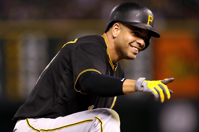 Pittsburgh Pirates' Aramis Ramirez points to teammates after his RBI triple off the Colorado Rockies on Tuesday.