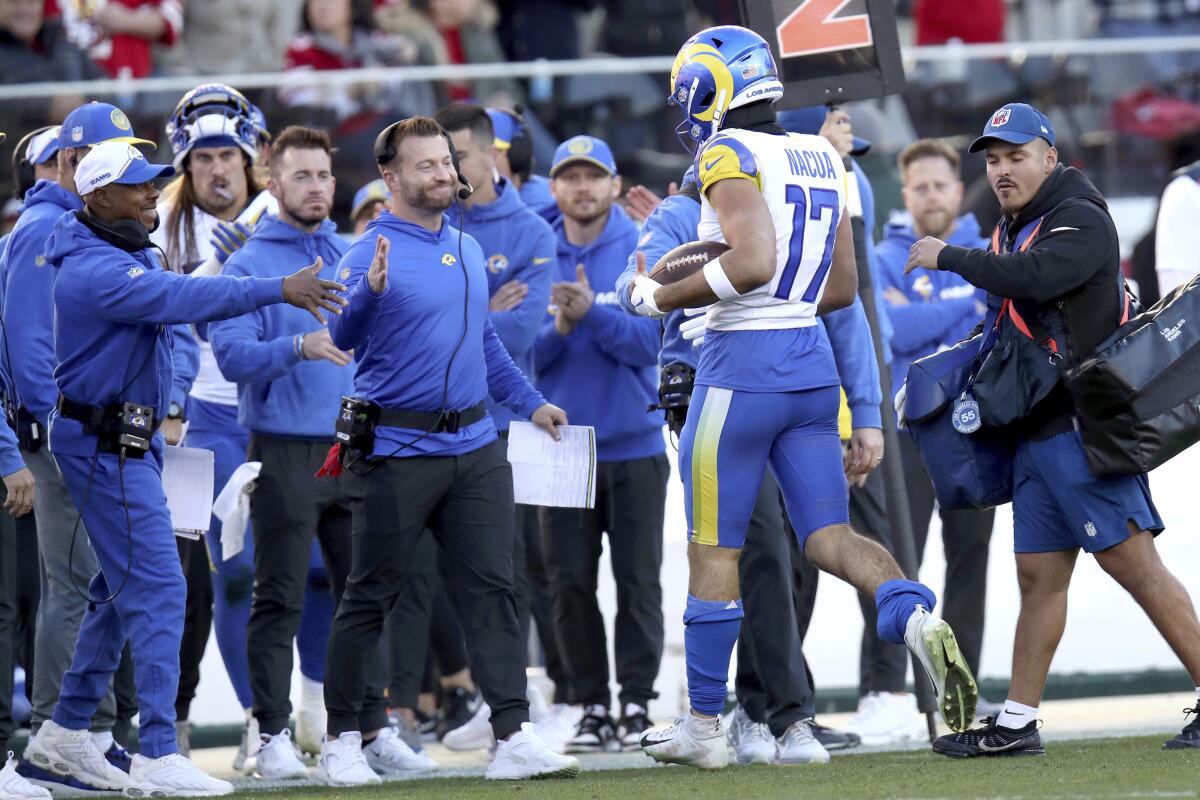 The Rams' Puka Nacua (17) is congratulated by coach Sean McVay after breaking two NFL rookie records.