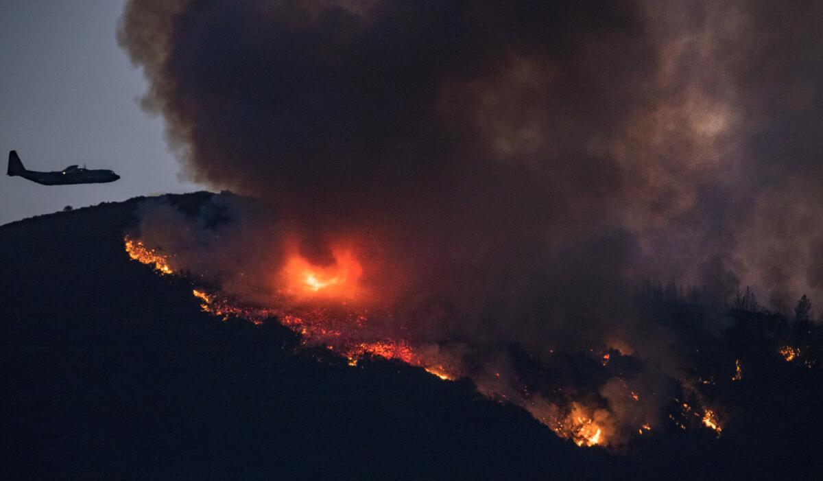 A plane prepares to make a fire retardant drop on the Holy fire burning in Cleveland National Forest.