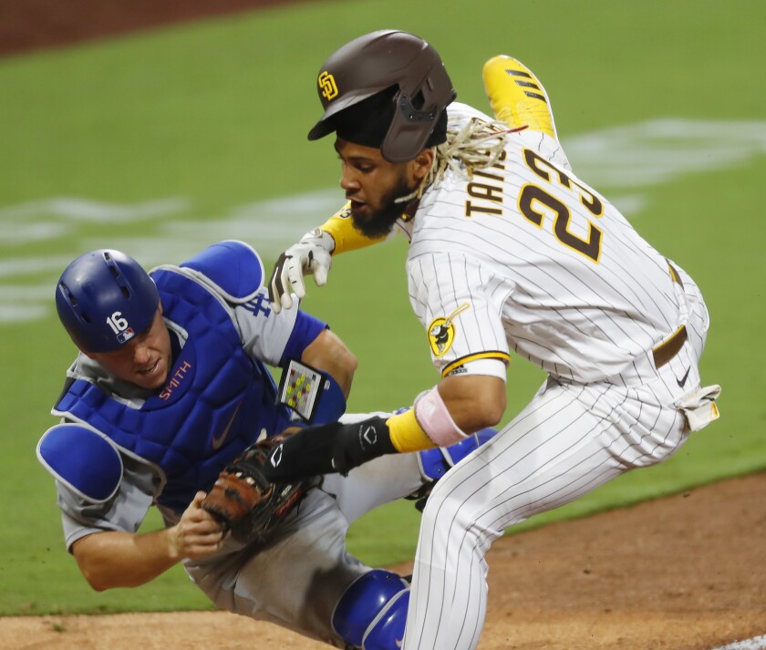 San Diego Padres Fernando Tatis Jr. collides with Los Angeles Dodgers catcher Will Smith at home plate.