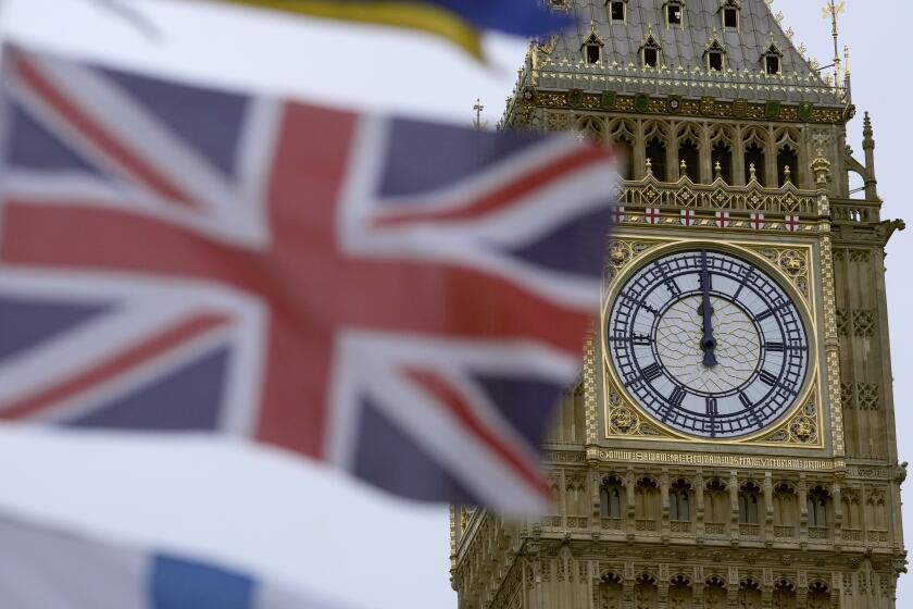 A British flag flies over a tourist kiosk on Westminster Bridge with the Elizabeth Tower part of the Palace of Westminster, which contains the bell known as Big Ben, in the background, London, Wednesday, Dec. 13, 2023. British lawmakers have voted on Tuesday in favor of the government's plan to send some asylum-seekers on a one-way trip to Rwanda. The House of Commons voted 313 to 269 to approve the government's Rwanda bill in principle. (AP Photo/Kin Cheung)