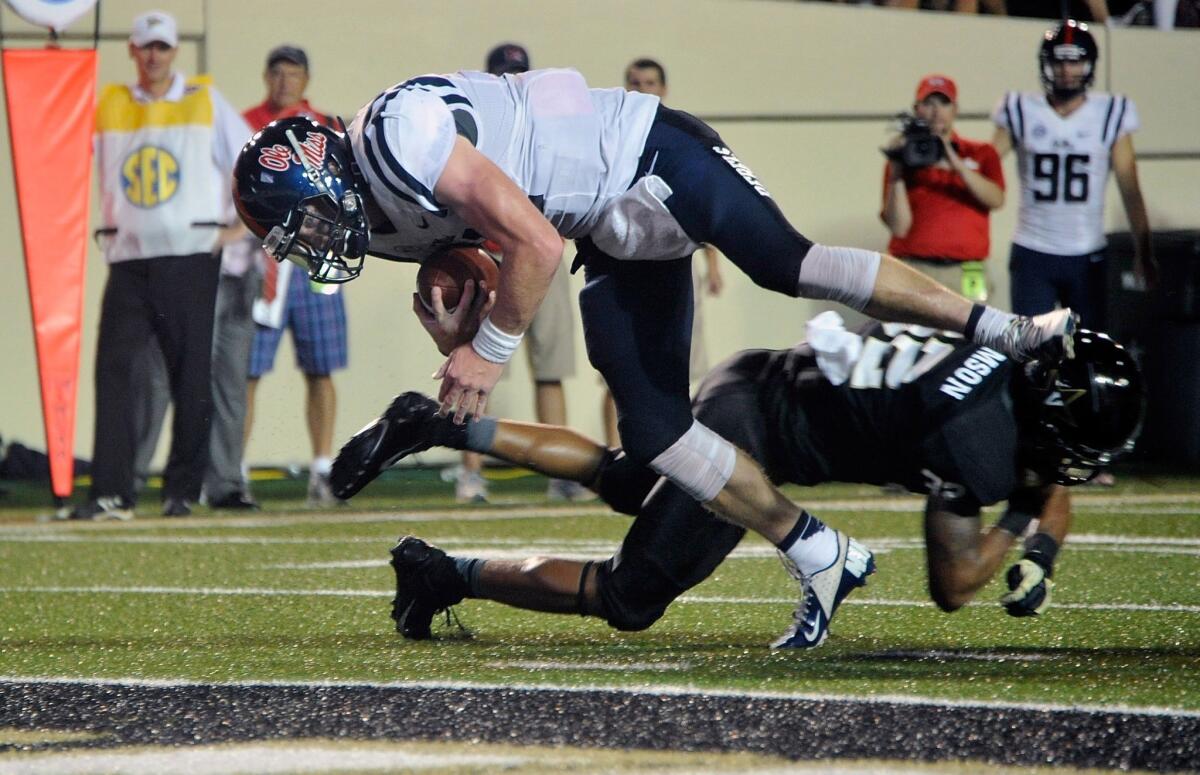 Mississippi quarterback Bo Wallace dives over Vanderbilt's Andrew Williamson to score during the Rebels' victory Thursday night. It wasn't the only exciting game to kickoff the college football season.