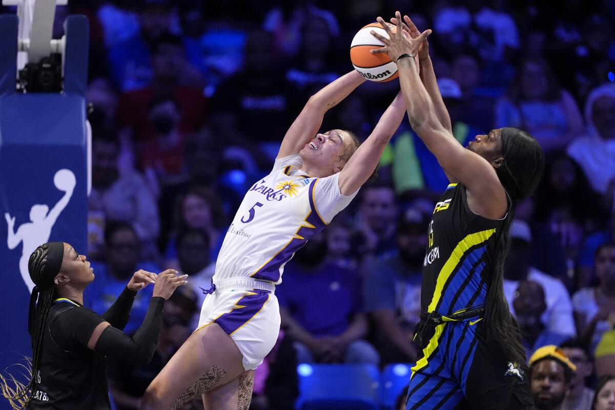 Sparks forward Dearica Hamby, left, reaches overhead with two hands to try to secure a rebound before Dallas' Teaira McCowan.