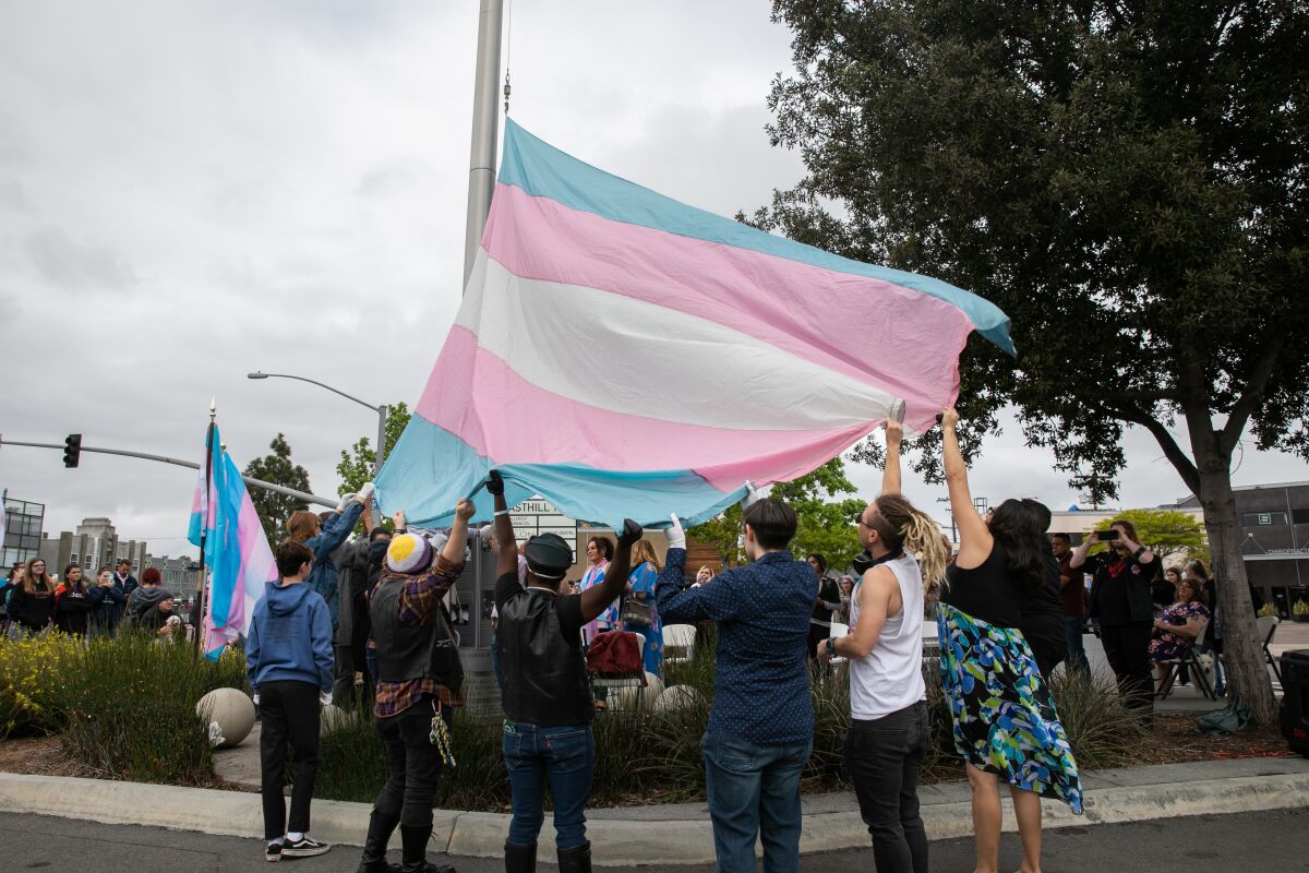 Voluntarios de San Diego izan la bandera del orgullo transgénero para el Día Internacional de la Visibilidad Transgénero 